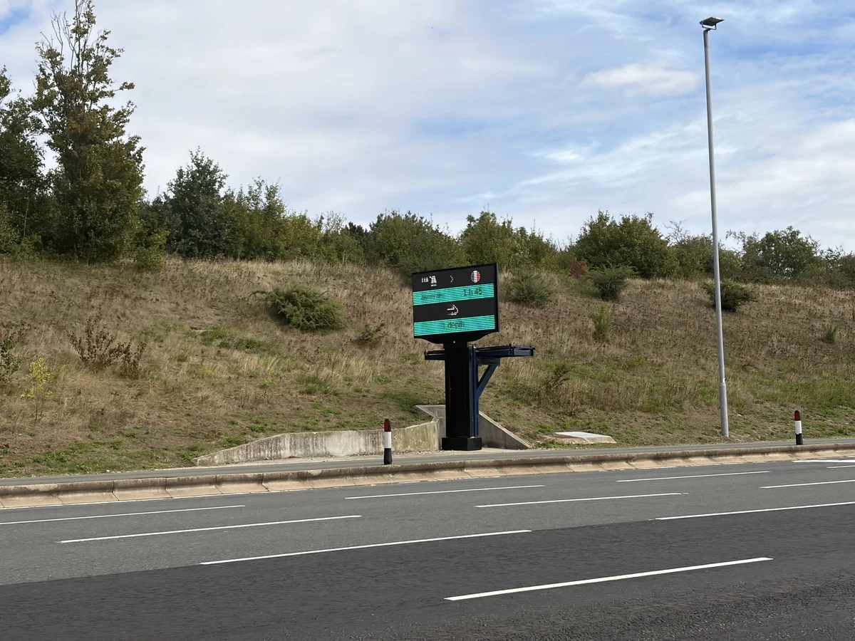 Panneau d'information numérique à l'accès du terminal Eurotunnel indiquant les horaires des navettes